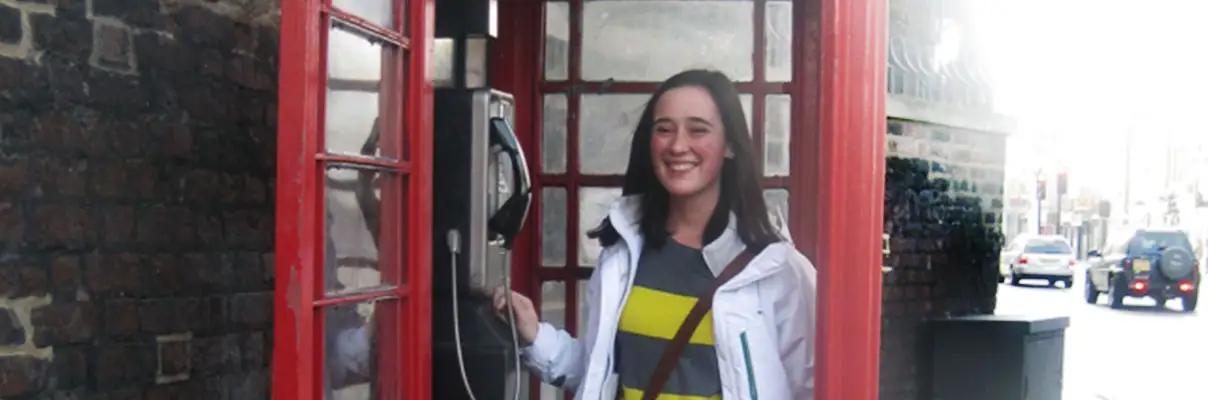 Author stands in a British red phone booth in London