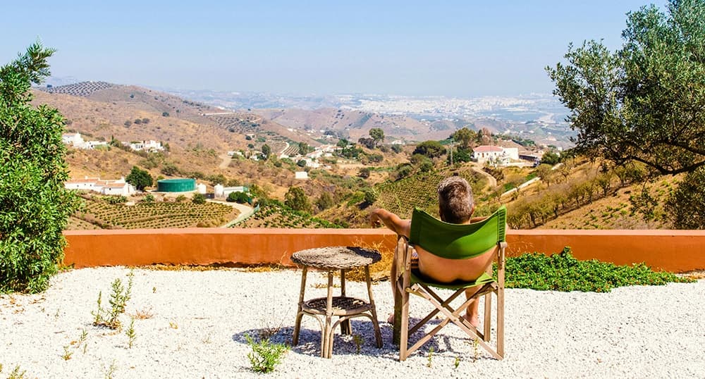 Man sitting in chair overlooking a view in Spain