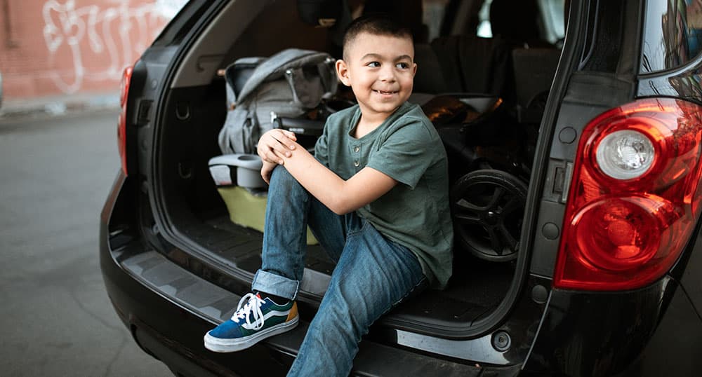 Boy sits in the back of a car