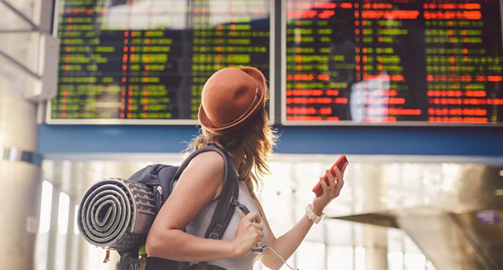 Woman looking at airport departure boards