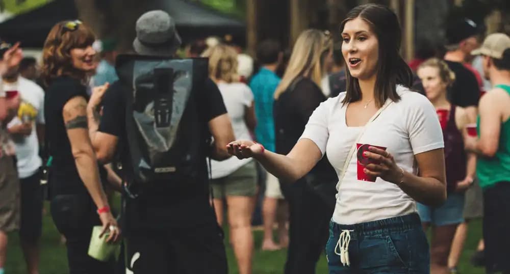 Woman plays a game while drinking at a festival