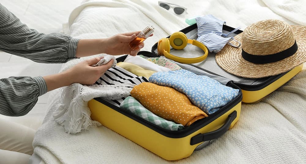 Woman packs a yellow suitcase