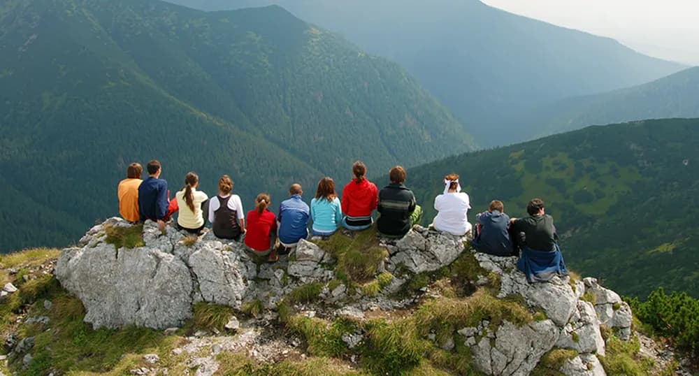 Group of friends viewing the mountains from the peak